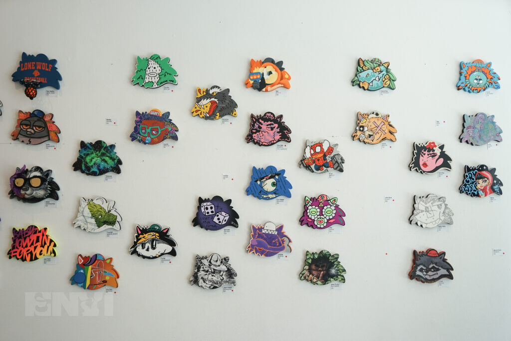 A collection of artworks displayed on a white wall.