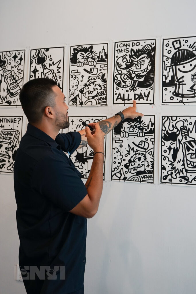 Jappy Agoncillo pointing at one of his artworks.