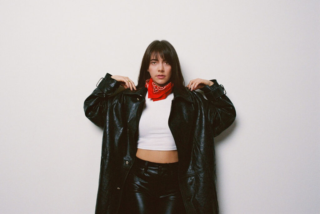 Marilyn Hucek posing against a white wall.