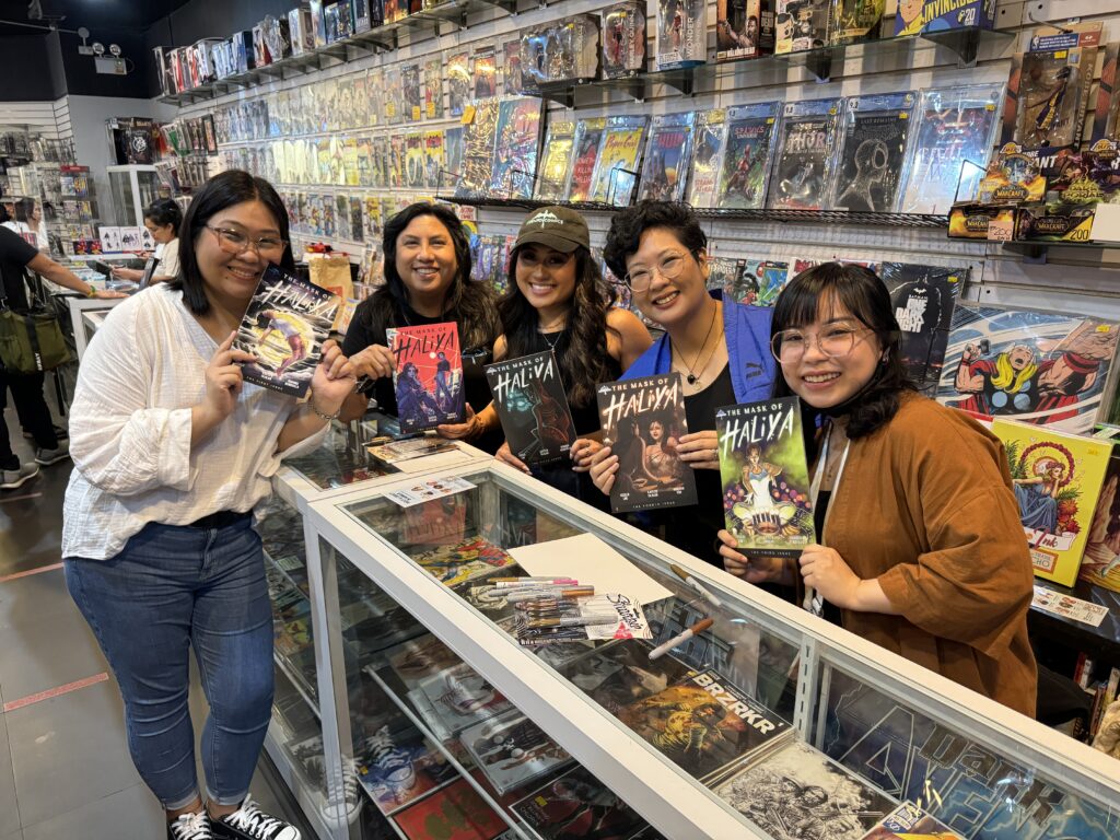 Several women posing with copies of The Mask of Haliya.