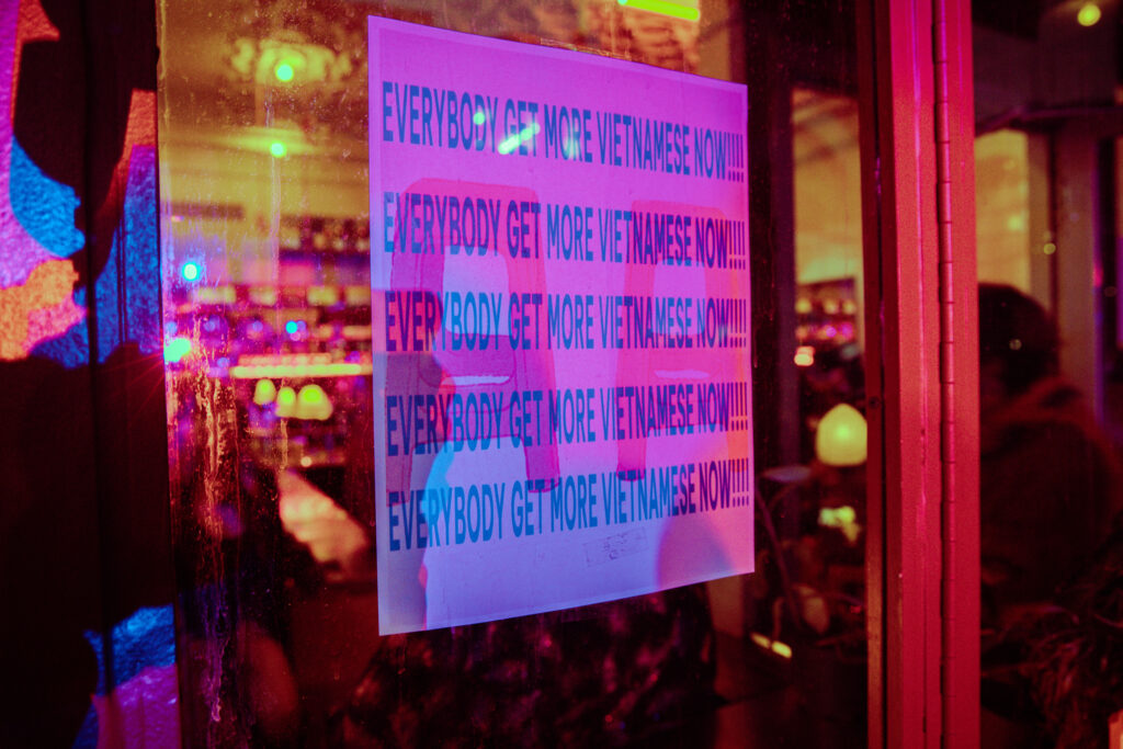 A poster saying "Everybody get more Vietnamese now!!!" in all capitalized letters repeated five times in a row.