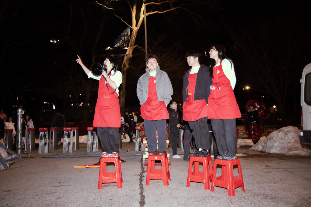 The event organizers of Pho With Friends standing on four red stools.