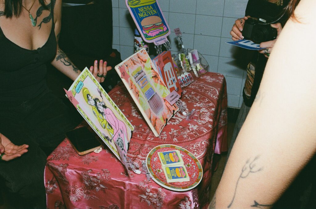 A table filled with merchandise and art works by Nessa Nguyen.