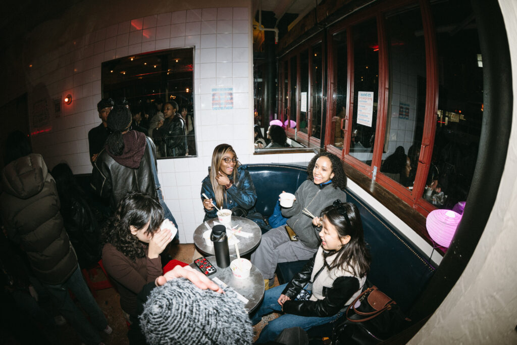 A group of adults chatting in a restaurant seat.
