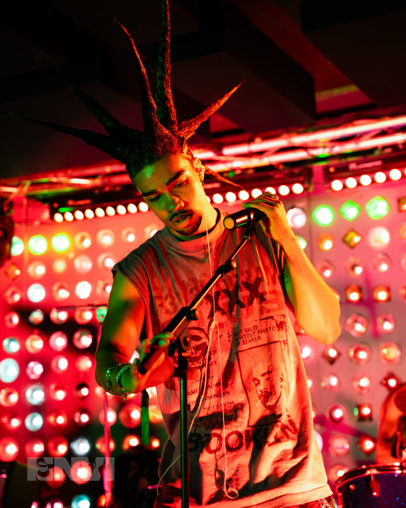 Danny Singh Adjusts the mic while performing at Baby's All Right.