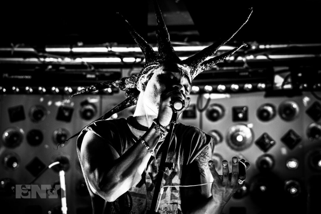 Danny Singh passionately emotes while holding a mic stand.