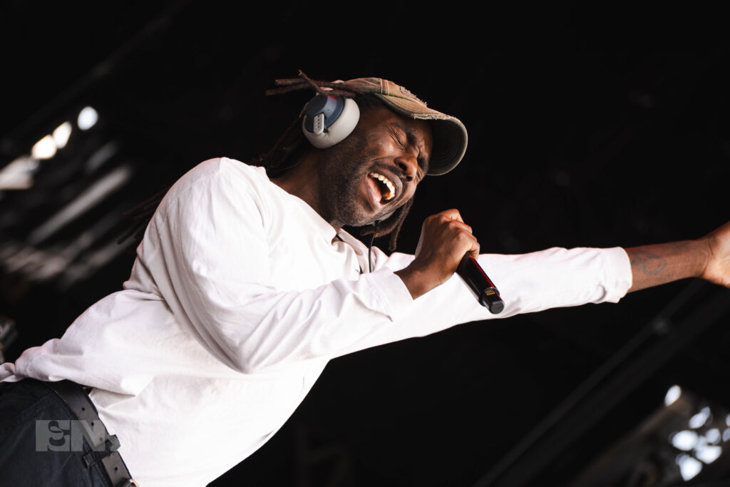 Blood Orange yells into a microphone while singing.